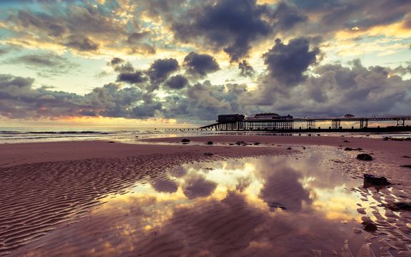 Tides out and the sun rises on Cromer beach, Norfolk, uk
