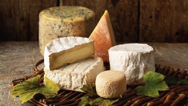 Variety of cheese on wicker tray.