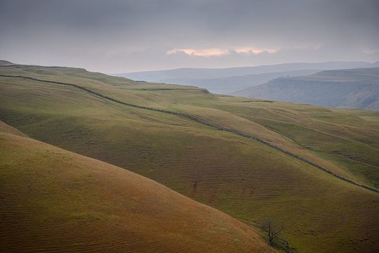 Sunrise over winding mountain road in Yorkshire dales, England.