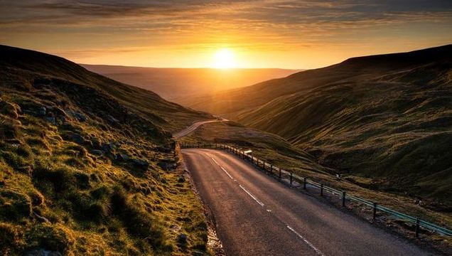 Sunrise over winding mountain road in Yorkshire dales, England.