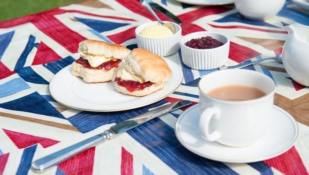 A traditional English cream tea scone with jam and cream.