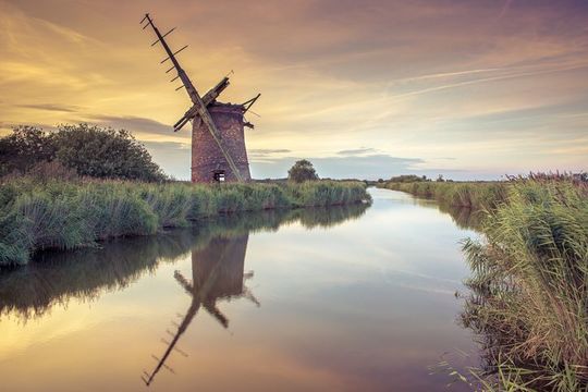 Abandoned Windmill on norfolk broads at sunset.