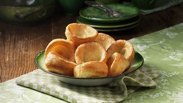 Bowl of Yorkshire pudding with green colour pottery.