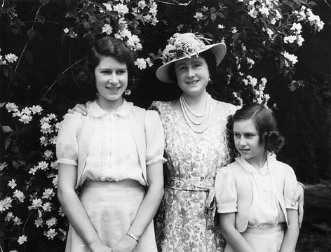 Queen Elizabeth with, on the left, her daughter Princess Elizabeth (later Queen Elizabeth II) and on the right Princess Margaret (1930 - 2002), in the garden at Windsor Castle during WW II.
