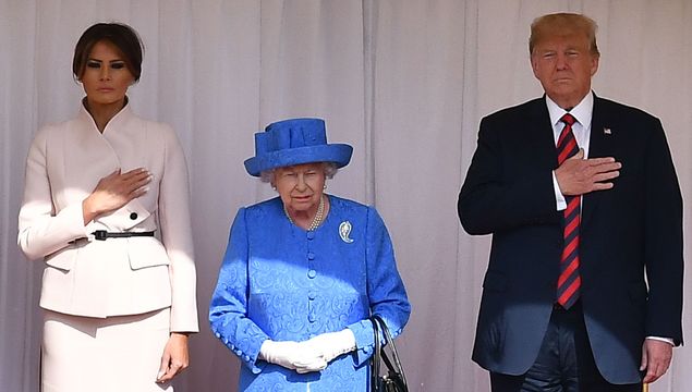 Britain\'s Queen Elizabeth II (C) stands with US President Donald Trump (R) and US First Lady Melania Trump (L) on the dias in the Quadrangle listening to a band of guardsmen play the US national anthem during a ceremonial welcome at Windsor Castle on July 13, 2018 in Windsor, England