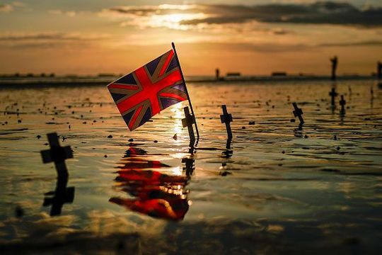 A Union Flag is planted alongside crosses on Gold Beach near the Mulberry harbour on the morning of the 75th anniversary of the D-Day landings on June 6, 2019