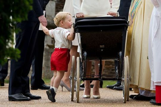  Prince George of Cambridge looks at his sister Princess Charlotte of Cambridge in her pram as he leaves the Church of St Mary Magdalene on the Sandringham Estate for her christening