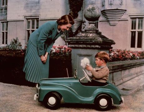 Princess Elizabeth watching her son Prince Charles playing in his toy car while at Balmoral. (Photo by Lisa Sheridan/Studio Lisa/Getty Images)