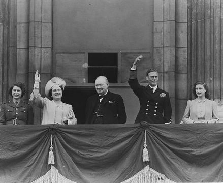 British prime minister Winston Churchill (1874 - 1965) (centre) with Queen Elizabeth, King George VI (1895 - 1952), Princess Elizabeth (left) and Princess Margaret Rose (1930 - 2002) waving from the balcony of Buckingham Palace during VE Day celebrations. (Photo by Reg Speller/Getty Images)