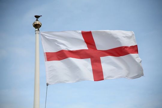 England St George flag blowing in the wind on a fine day. With a robin red breast sat on flagpole!