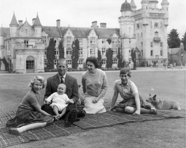 Queen Elizabeth II and Prince Philip, Duke of Edinburgh with their children, Prince Andrew (centre), Princess Anne (left) and Charles, Prince of Wales sitting on a picnic rug outside Balmoral Castle in Scotland.