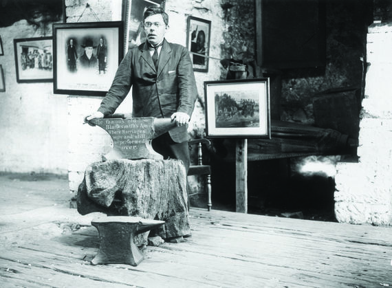 June 1929: Rochard Rennison blacksmith at Gretna Green with the old anvil over, which he is licensed to marry people.