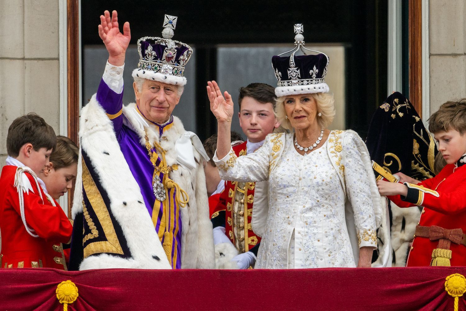 Король Чарльз и королева-консорт Камилла приветствуют публику с балкона Букингемского дворца после их коронации.