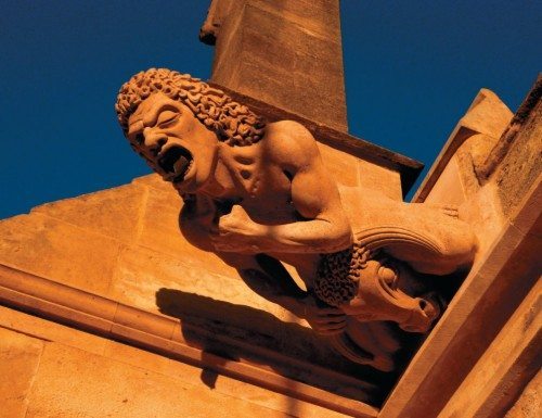 A gargoyle perched of Gloucester Cathedral.